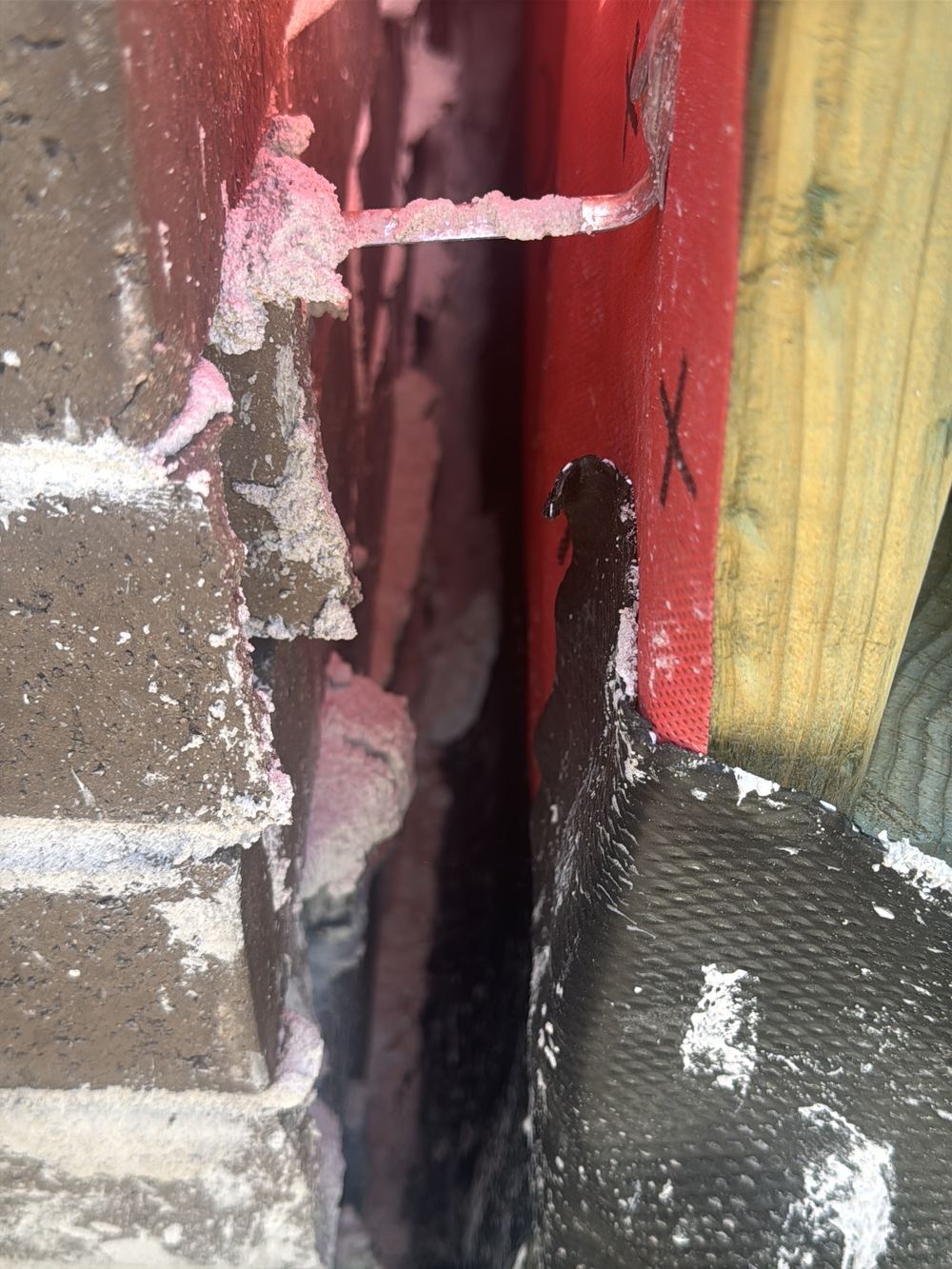 Mortar droppings lying on the damp course, which can bridge moisture across it, Rouse Hill